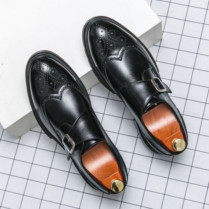 Men's dress shoes featuring elegant wingtip brogue detailing and a stylish single buckle closure, crafted in a sophisticated leather look, perfect for formal occasions. 1