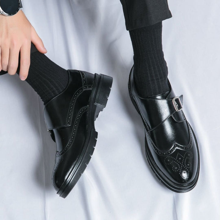 Men's dress shoes featuring elegant wingtip brogue detailing and a stylish single buckle closure, crafted in a sophisticated leather look, perfect for formal occasions. 2