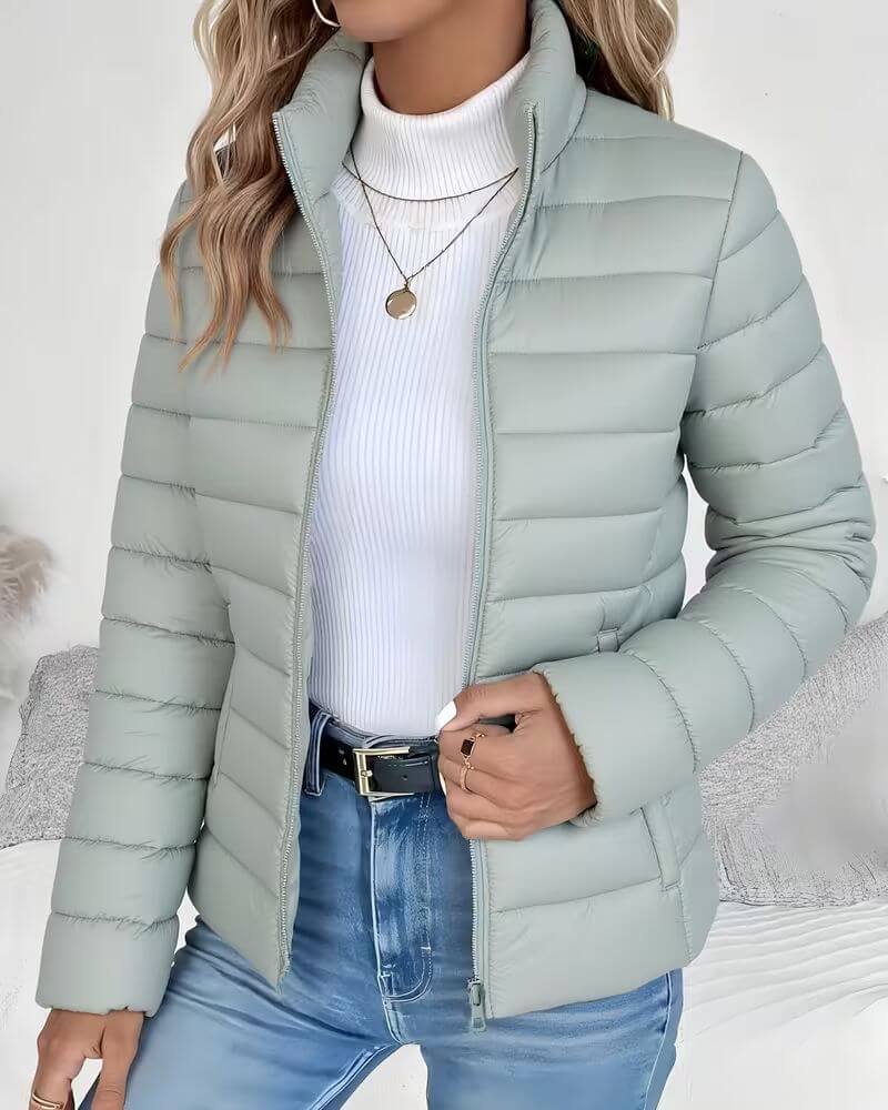 Lightweight women's puffer jacket with a stand collar, featuring a quilted design and hip-length cut, perfect for winter wear. 0