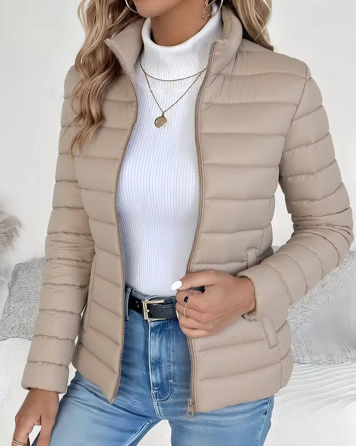 Lightweight women's puffer jacket with a stand collar, featuring a quilted design and hip-length cut, perfect for winter wear. 2